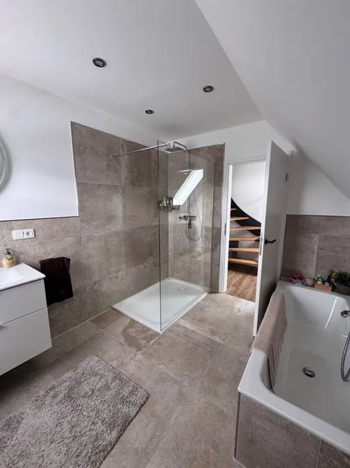 Modern Badezimmer mit begehbarer Glasdusche, braunen Fliesen und weißer Badewanne