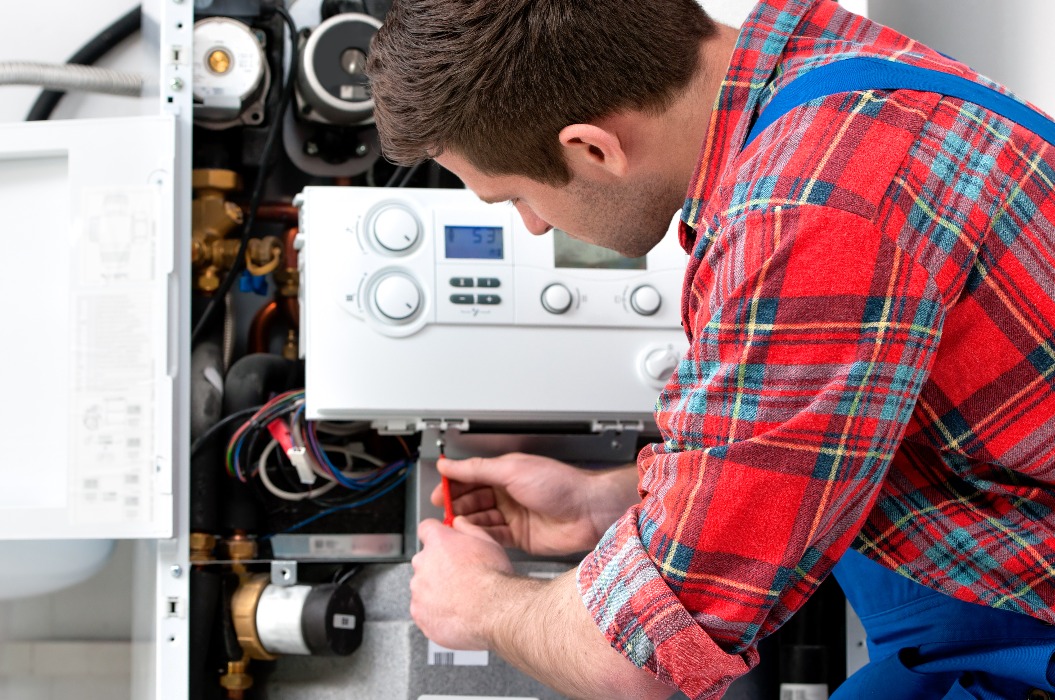 Techniker bei der Wartung eines Heizkessels